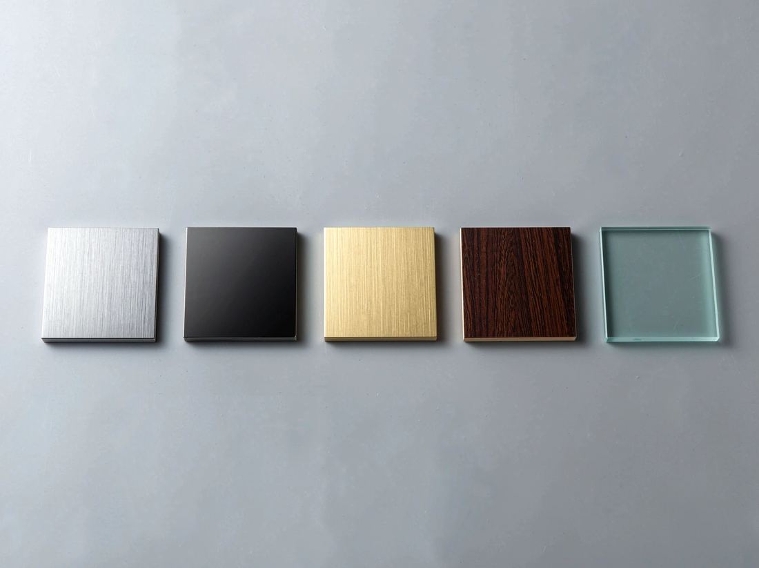 Brushed steel, black titanium, champagne-gold, walnut veneer and glass material samples