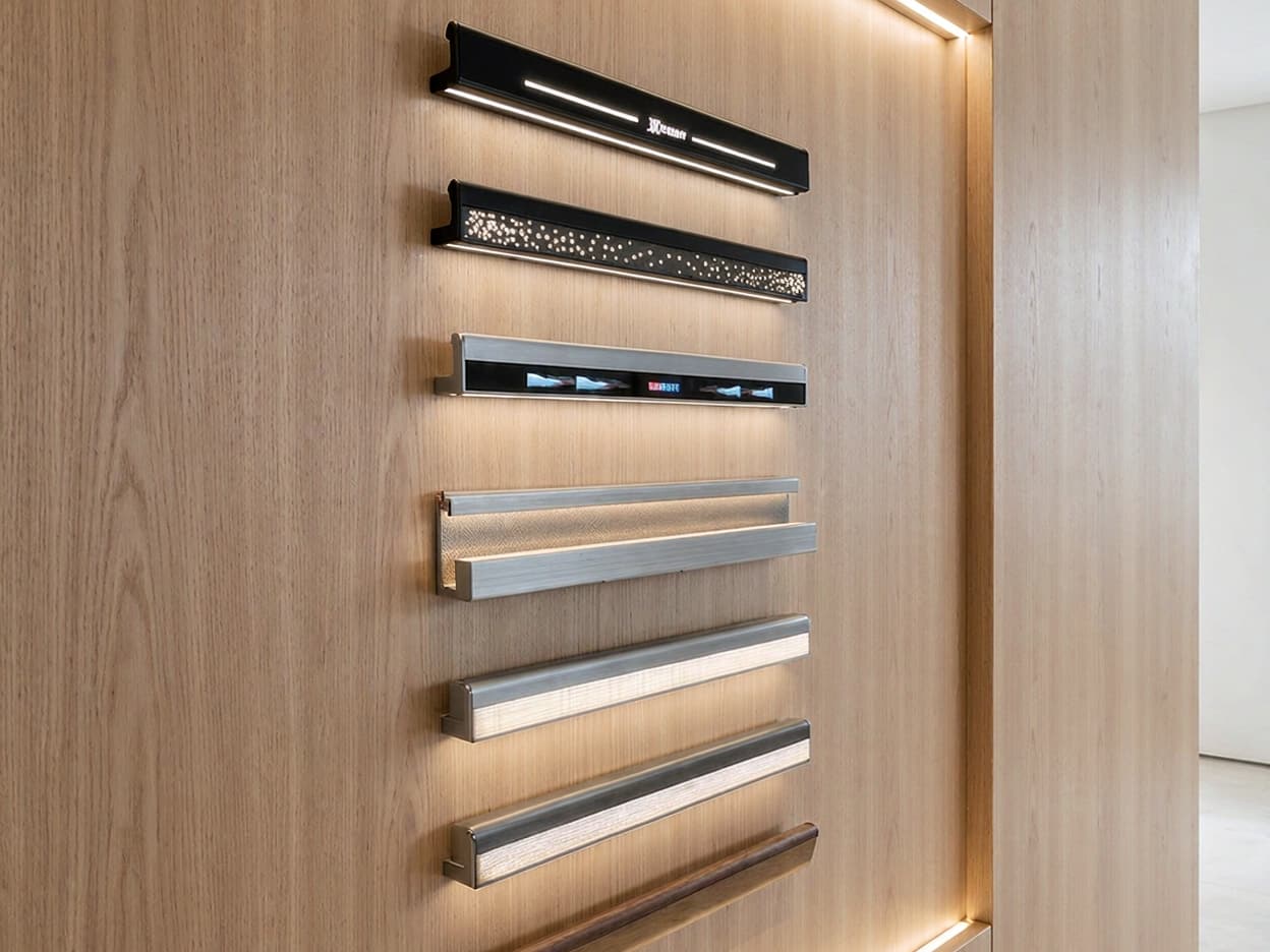 SINNVO handrail and trim profiles in brushed steel, bronze and black on an oak display panel